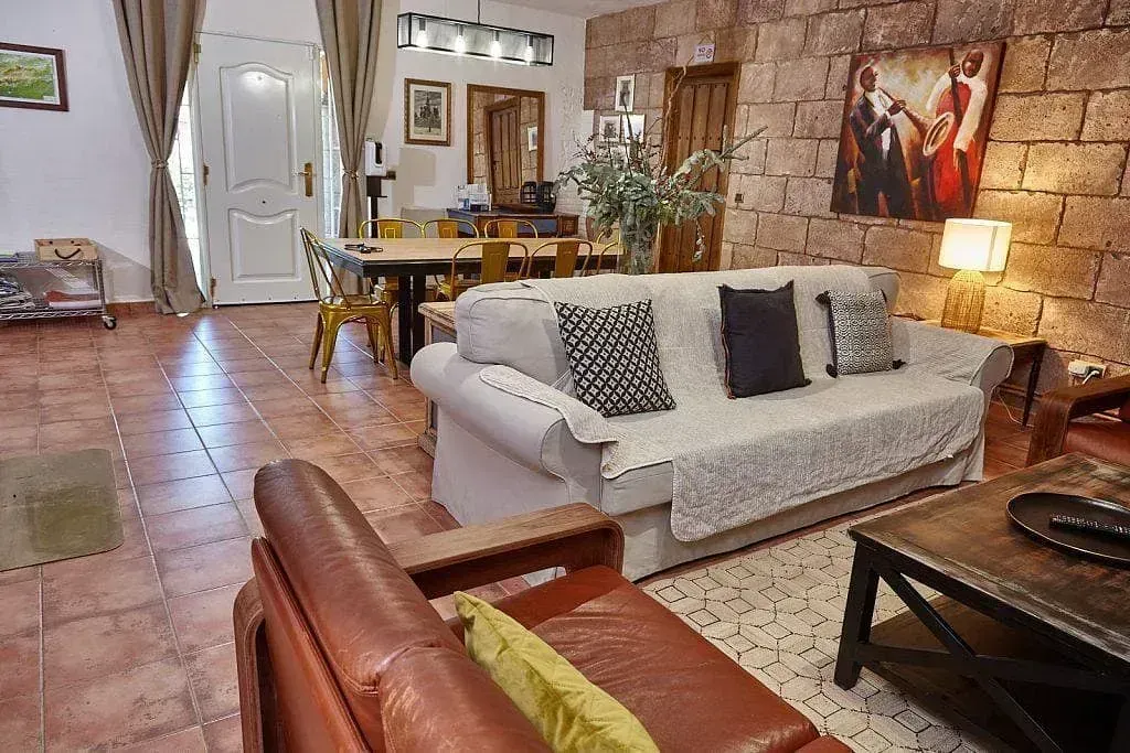 Una sala de estar con un sofá, una silla, una mesa de café y un cuadro en la pared.