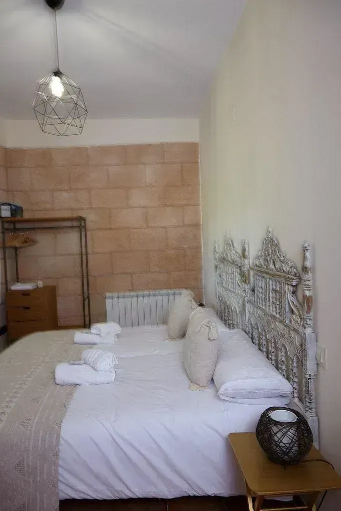 Un dormitorio con una cama, mesita de noche y lámpara.