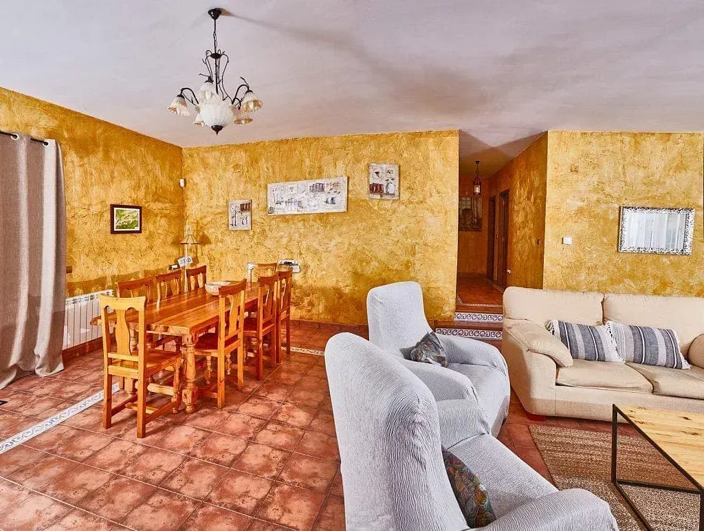 Una sala de estar con un sofá, sillas, una mesa y una lámpara de araña.