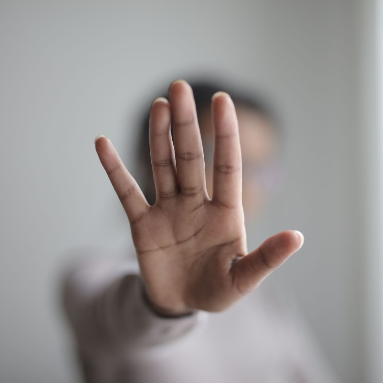 Eine ausgestreckte Hand in abwehrender Haltung.