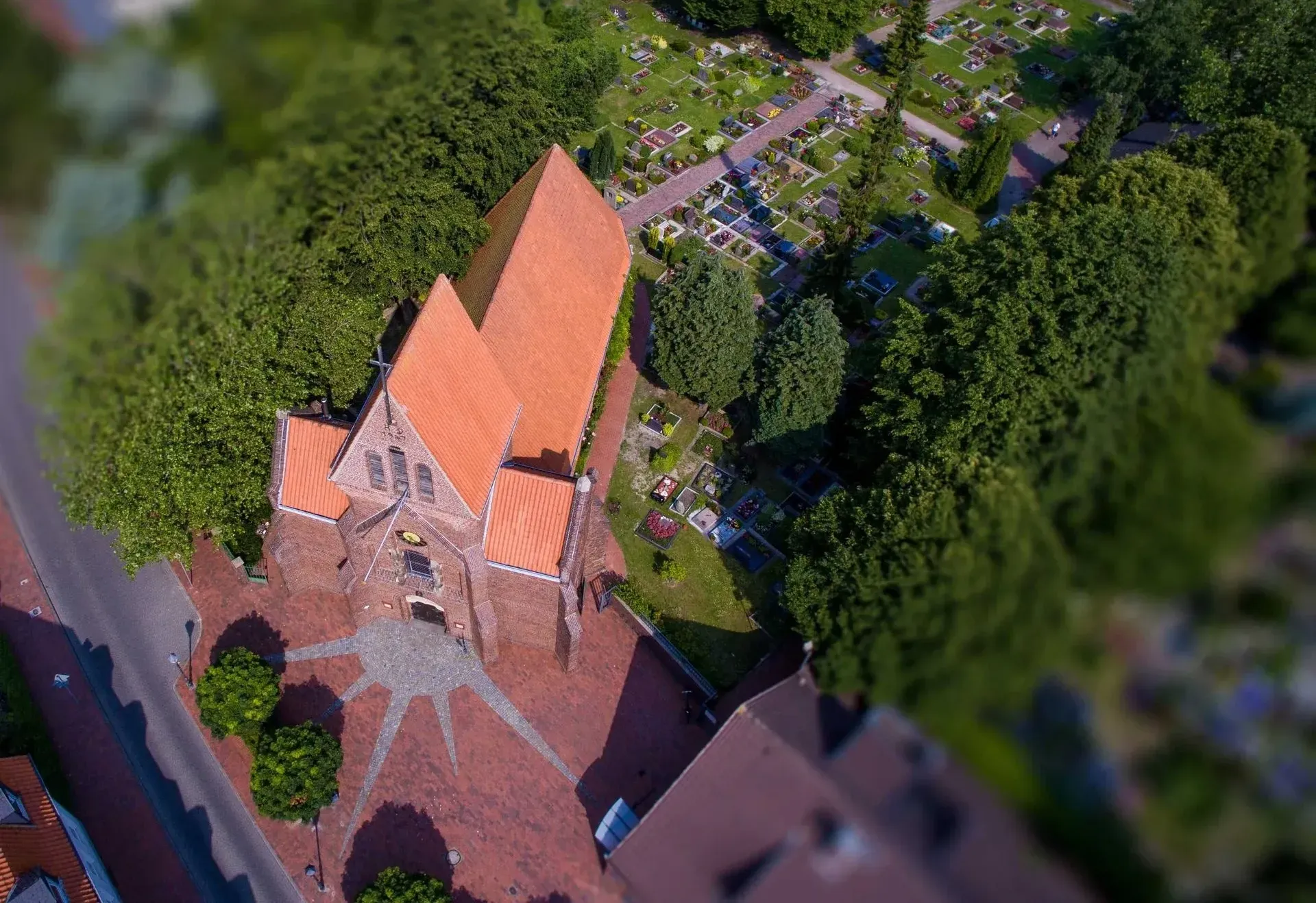 Der Innenraum einer Kirche. Zu sehen sind u.a. hellgraue Bankreihen, eine geschnitzte Kanzel und ein Altar mit Retabel.