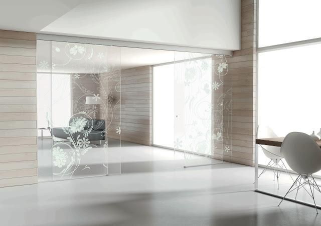 Una sala de estar con sofá, mesa, sillas y puertas corredizas de vidrio.