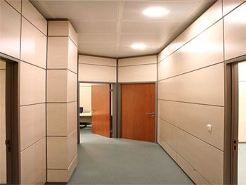 Un largo pasillo con una puerta de madera en el medio.