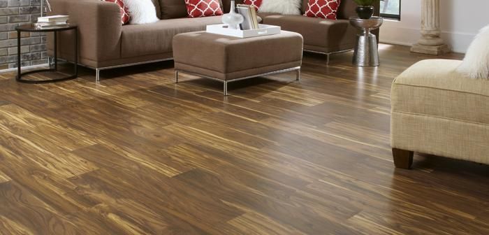Una sala de estar con pisos de madera, un sofá, sillas y una mesa de café.