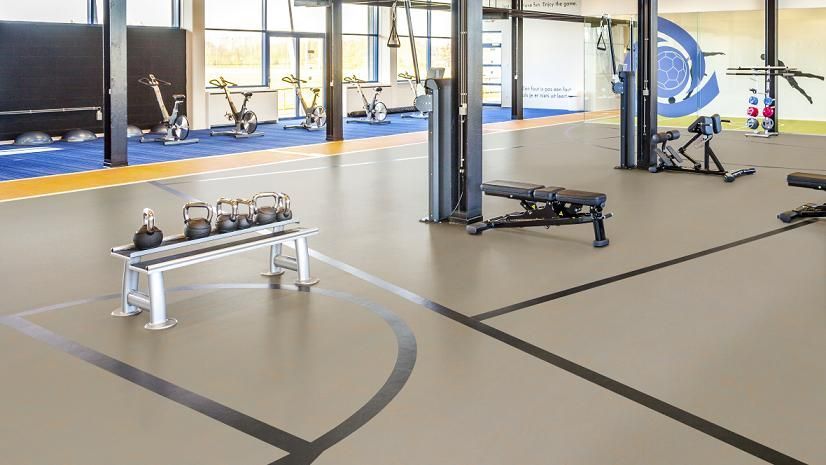 Hay una cancha de baloncesto en el medio del gimnasio.