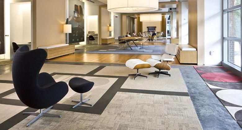 Una sala de estar con una silla de huevo negra y una otomana.