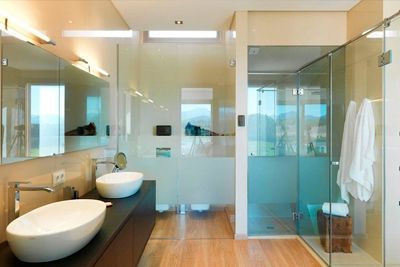 Un baño con dos lavabos y ducha.