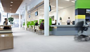 Una persona en silla de ruedas camina por el vestíbulo de un hospital.