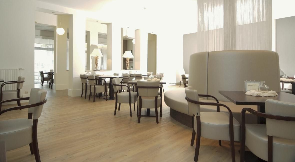 Un restaurante con mesas y sillas en una sala grande.