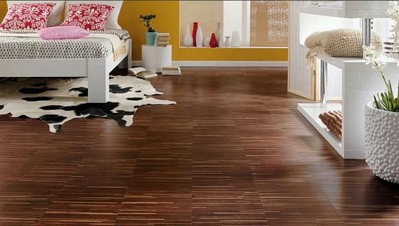 Un dormitorio con una cama y una alfombra de piel de vaca en el suelo.