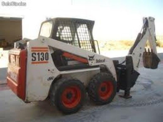 Un minicargador Bobcat S130 está estacionado en un estacionamiento.