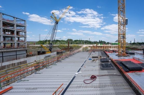 Un gran edificio en construcción con una grúa al fondo.