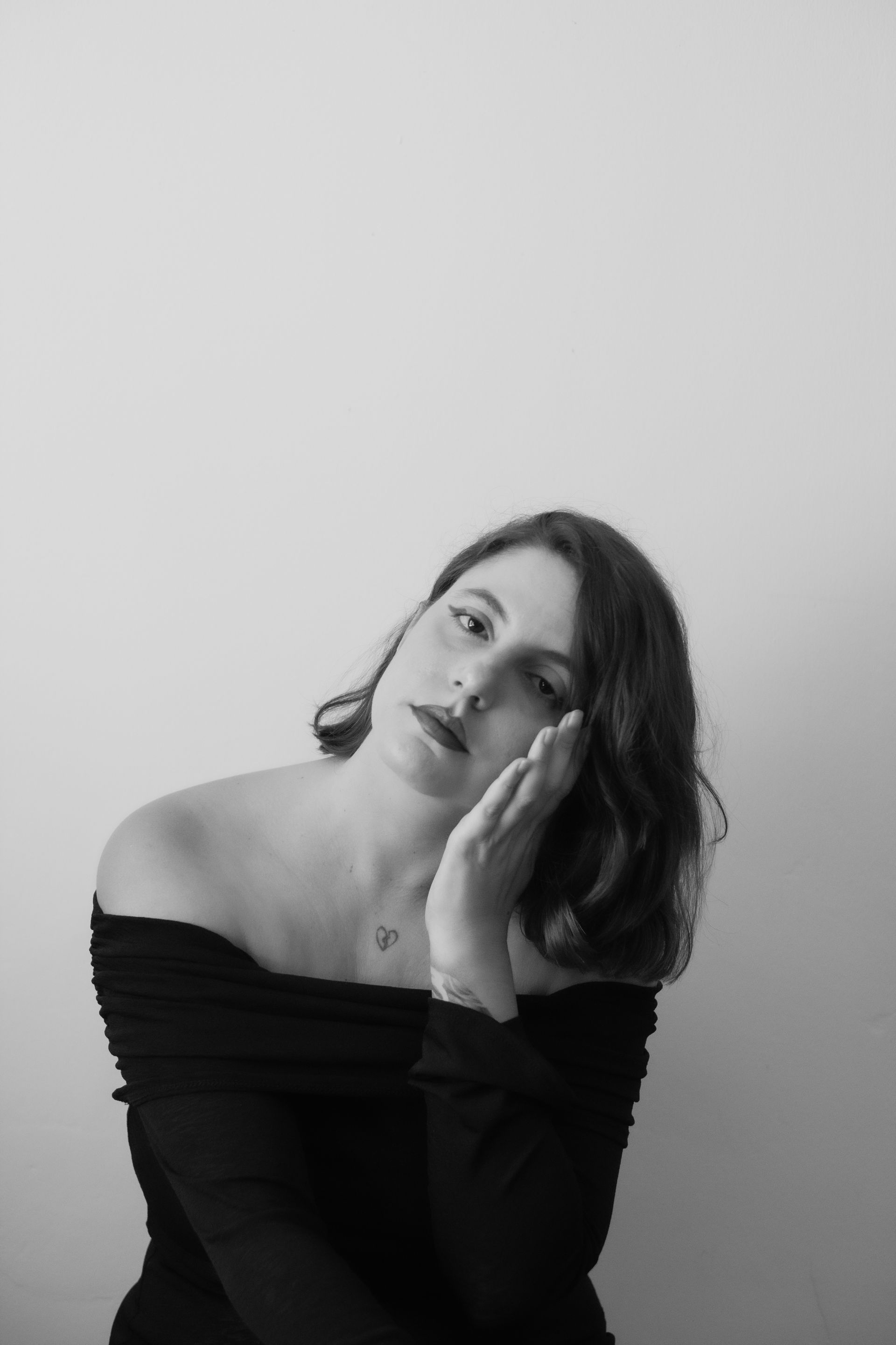 Mujer con gafas sonríe, mirando a la derecha. Retrato en blanco y negro.