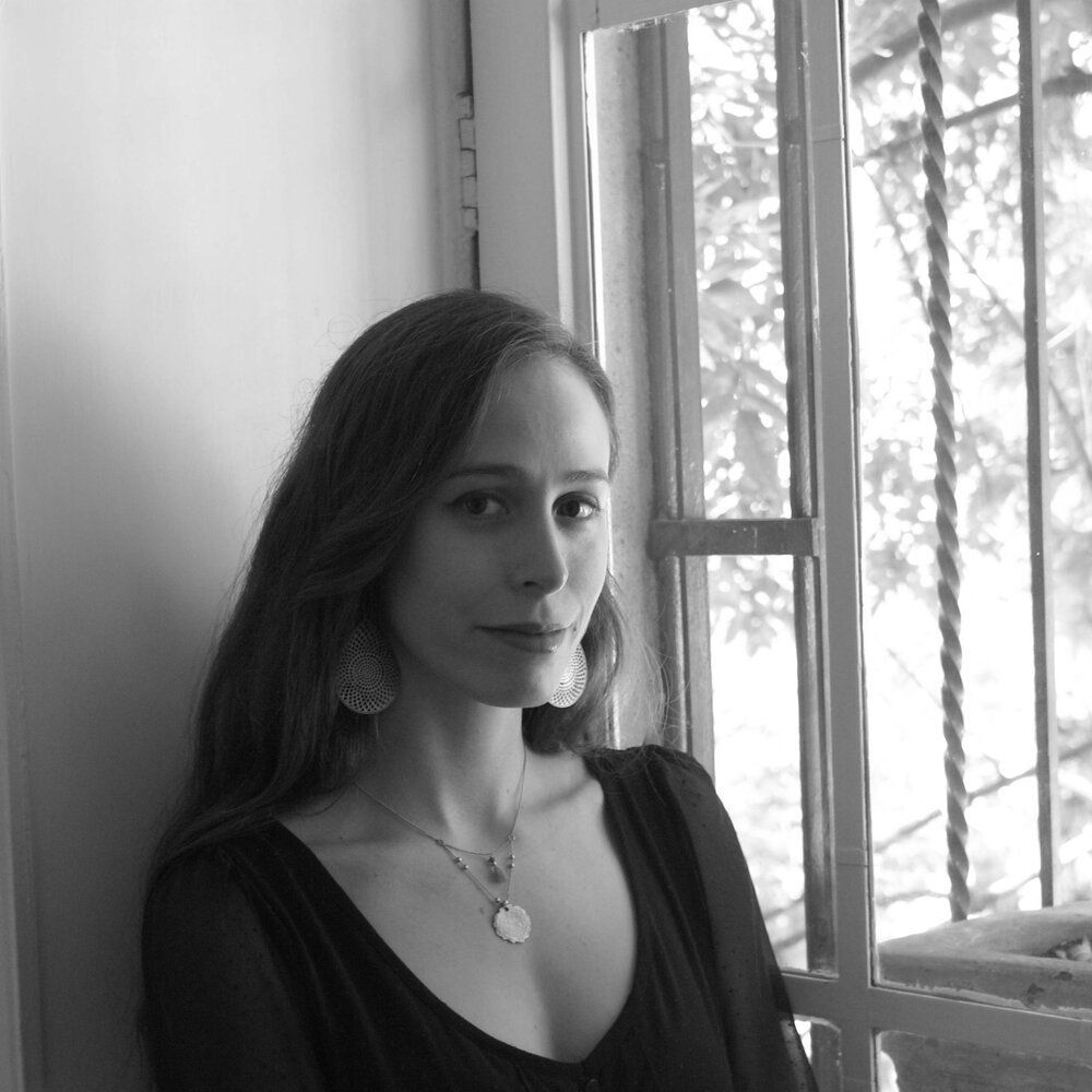 Mujer con los ojos cerrados y pendientes colgantes, en blanco y negro.