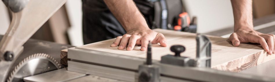 Una persona está cortando un trozo de madera con una sierra circular.