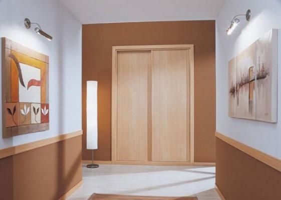 Un pasillo con un cuadro en la pared y una lámpara.