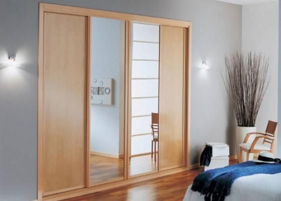 Un dormitorio con puertas correderas y una cama.