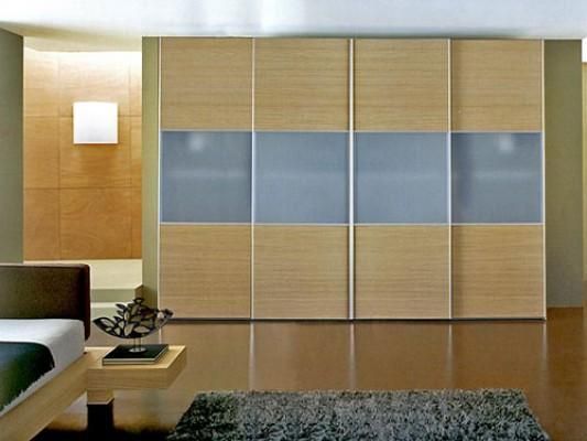 Un dormitorio con puertas correderas y una cama.