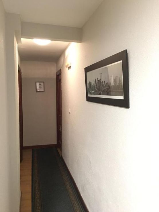Un largo pasillo con un cuadro en la pared.