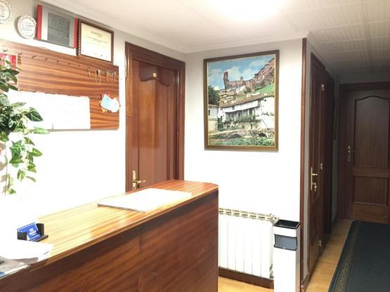 Un pasillo con un mostrador de madera y un cuadro en la pared.