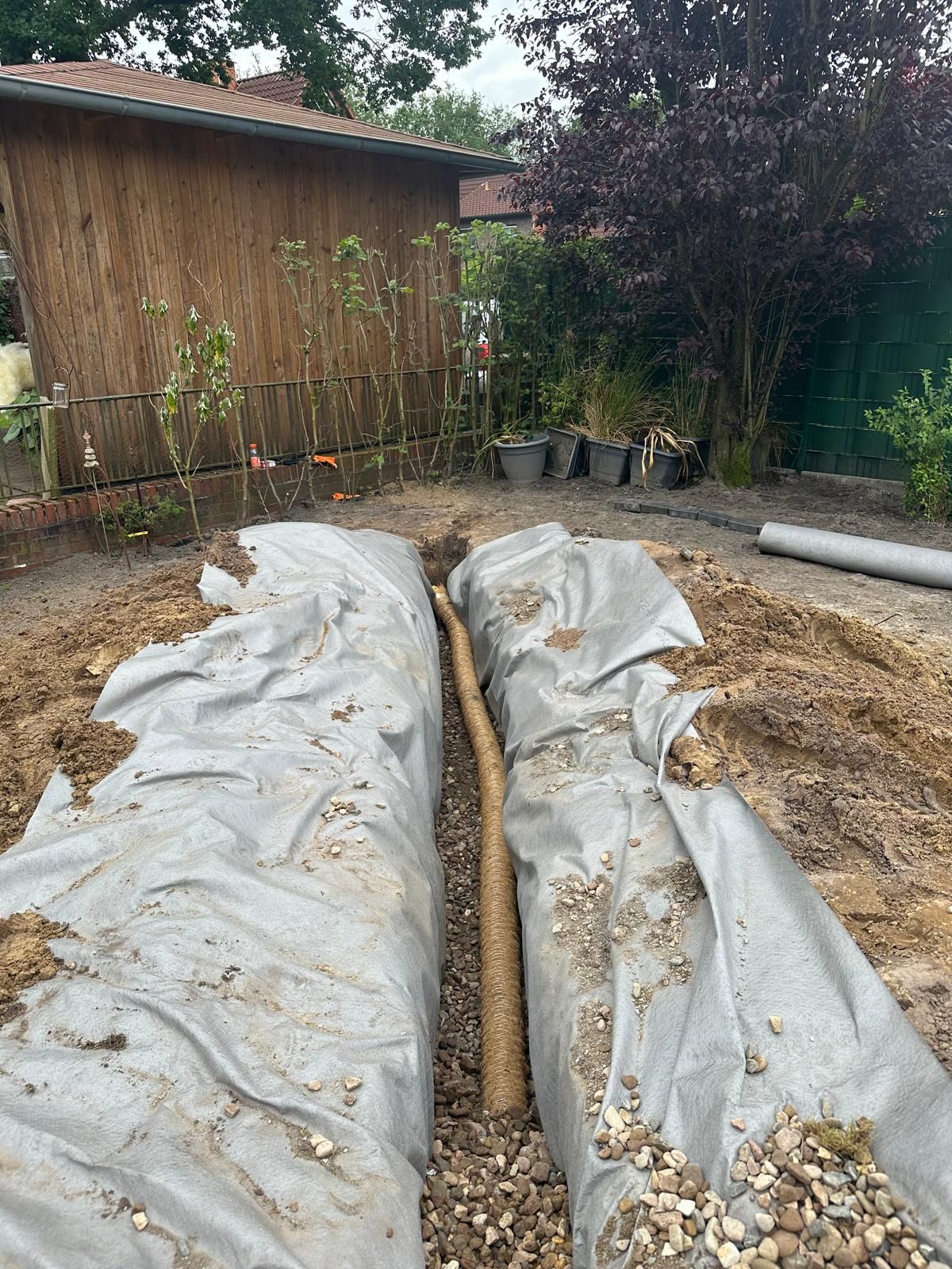 In einem Hinterhof wird ein Entwässerungssystem gebaut.