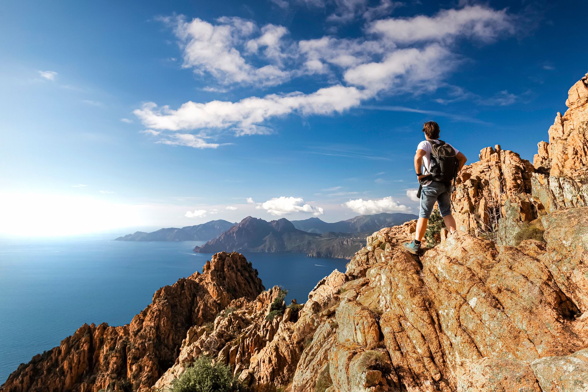 Homme en haut d'une falaise regardant le paysage
