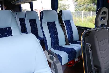 Das Innere eines Busses mit blauen und weißen Sitzen.