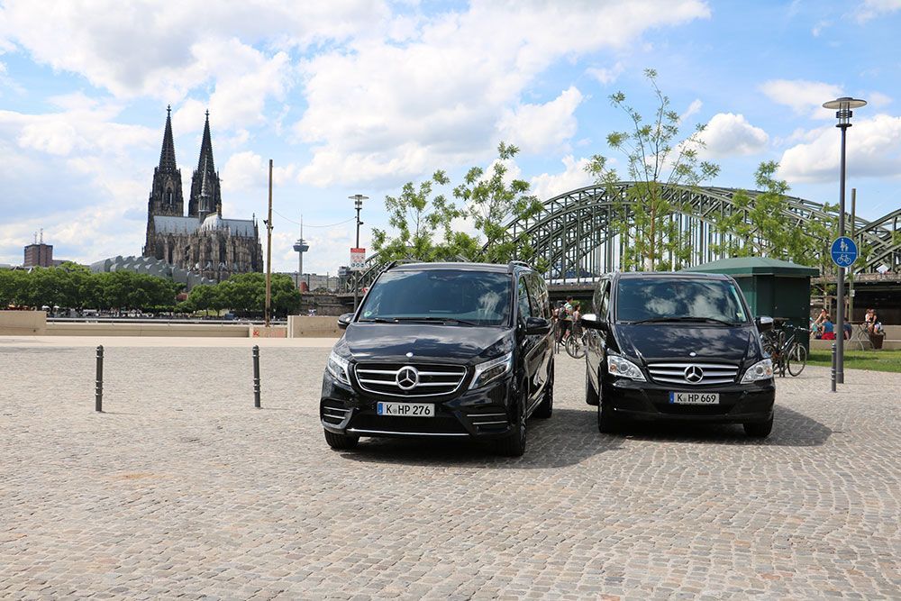 Zwei Mercedes-Transporter stehen vor einer Brücke