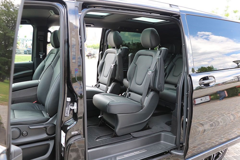 Das Innere eines schwarzen Lieferwagens mit geöffneten Türen und umgeklappten Sitzen.