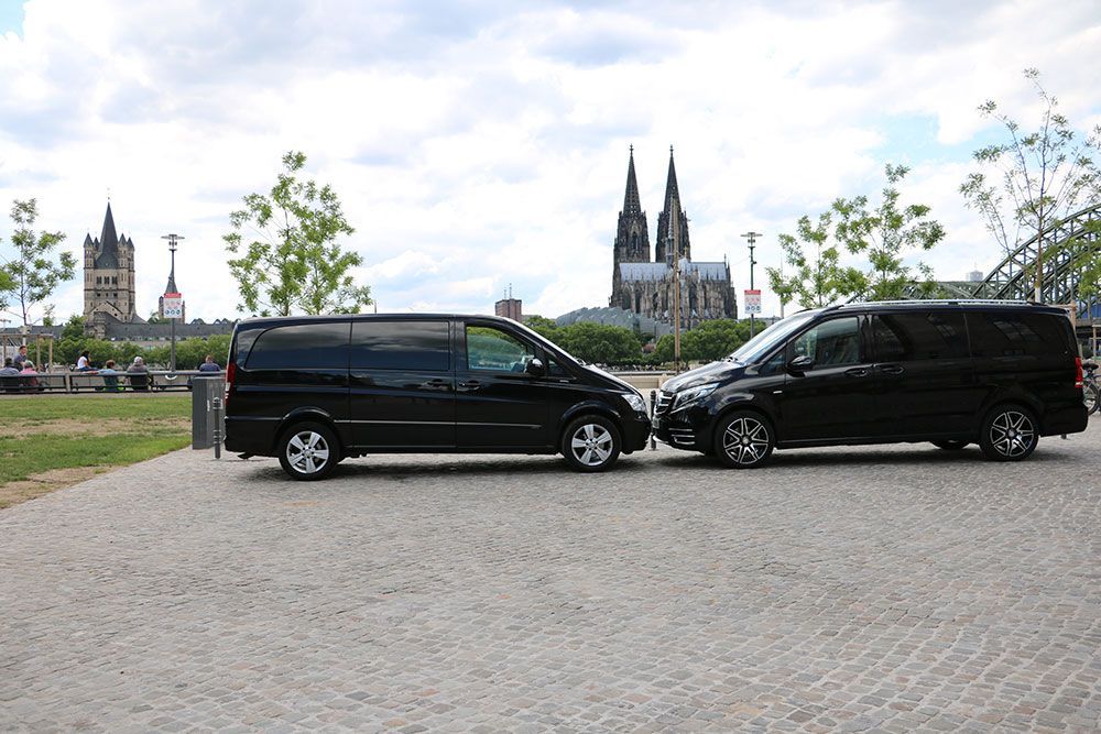 Zwei schwarze Lieferwagen stehen nebeneinander auf einer Kopfsteinpflasterstraße