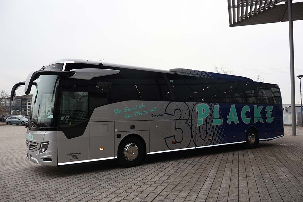 Ein silber-blauer Bus mit dem Wort Placke auf der Seite