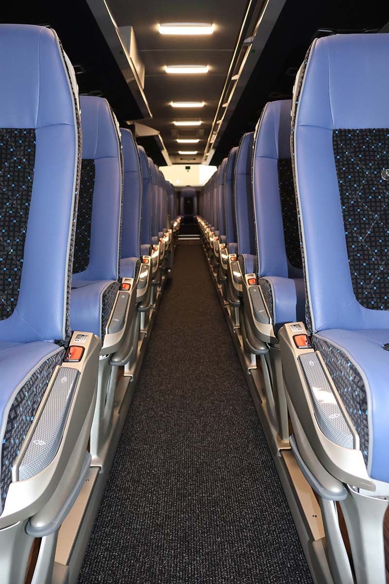 Ein langer Gang mit blauen Sitzen in einem Bus