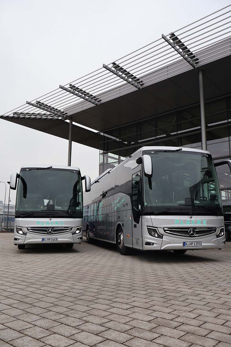 Zwei Setra Busse stehen vor einem Gebäude