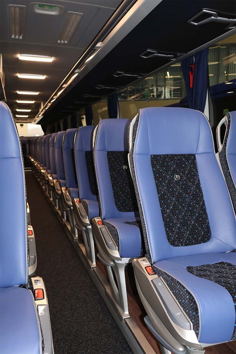 Eine lange Reihe blauer Sitze in einem Bus