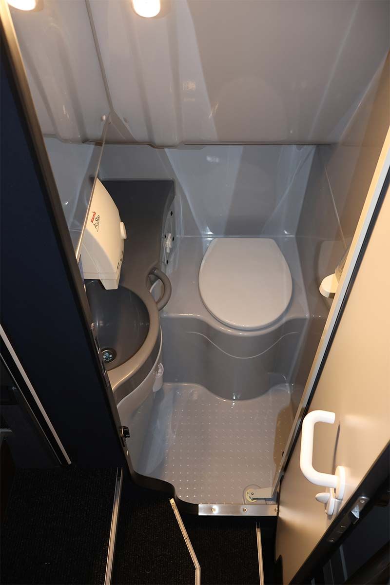 Ein Badezimmer mit Toilette und Papierhandtuchspender