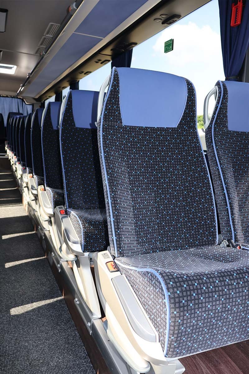 Eine lange Reihe blauer Sitze in einem Bus
