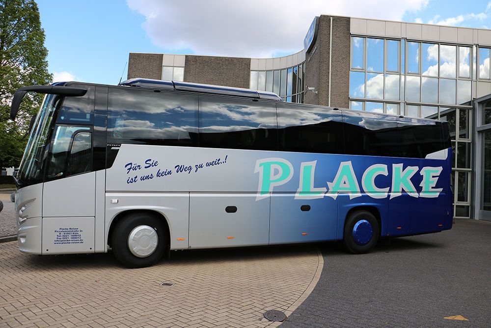 Ein blau-weißer Placke-Bus steht vor einem Gebäude