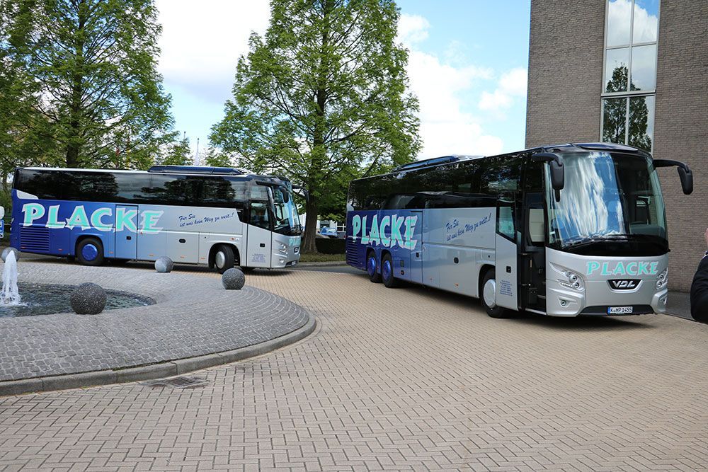 Eine Reihe von Placke-Bussen, die vor einem Gebäude geparkt sind