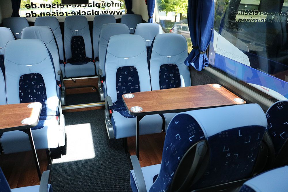 Das Innere eines Busses mit blauen Sitzen und Tischen