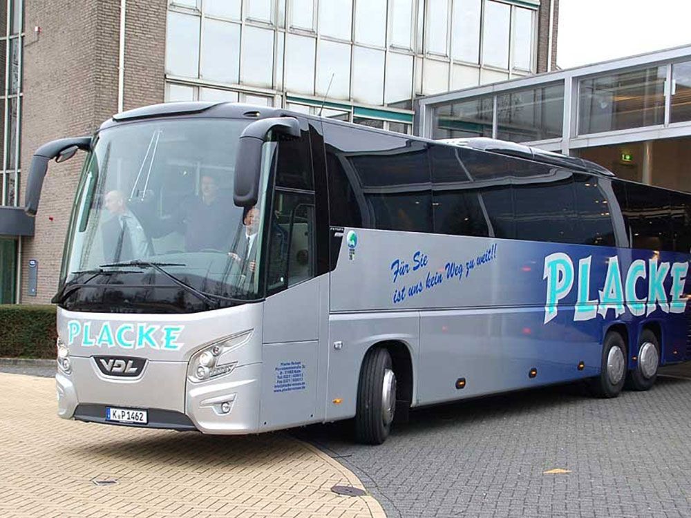 Ein silber-blauer Placke-Bus steht vor einem Gebäude