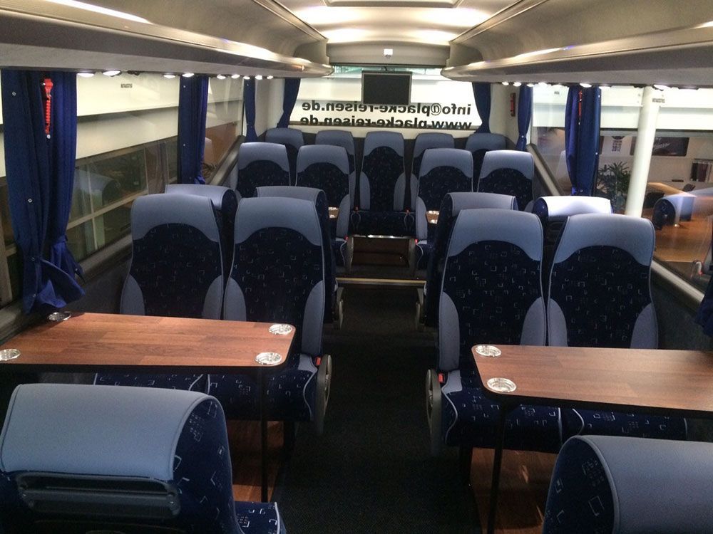 Das Innere eines Busses mit blauen Sitzen und Tischen