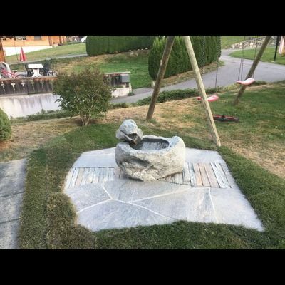 Il y a une fontaine au milieu de l'herbe dans l'arrière-cour.