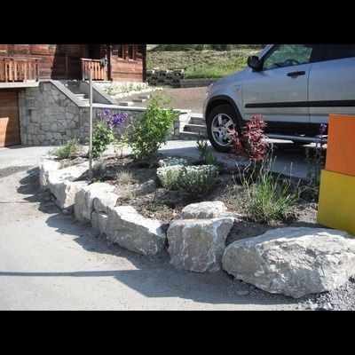 Une voiture argentée est garée devant une maison