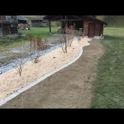 Un chemin menant à une maison avec un hangar en arrière-plan.