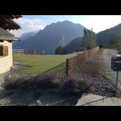Une boîte aux lettres devant une maison avec des montagnes en arrière-plan