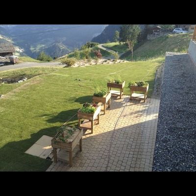 Un groupe de jardinières en bois posées au sommet d'un patio en briques.