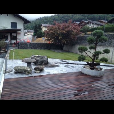 Une terrasse en bois avec un bonsaï dessus