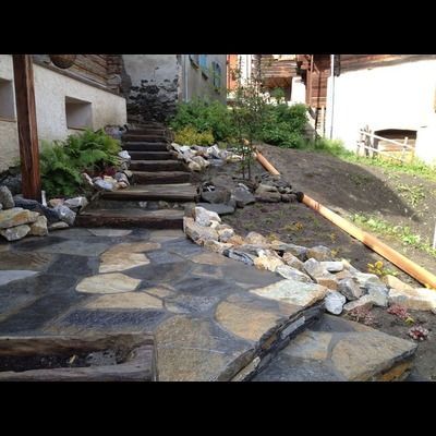 Une allée en pierre avec des escaliers menant à une maison