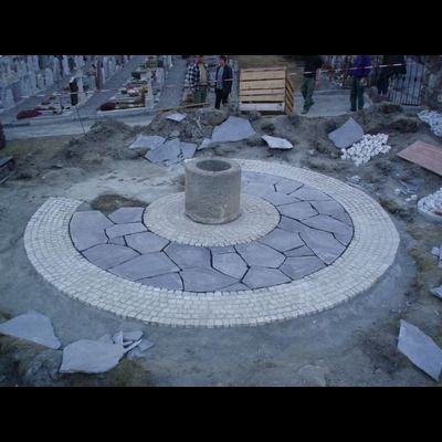 Une allée circulaire en pierre est en cours de construction dans un cimetière.