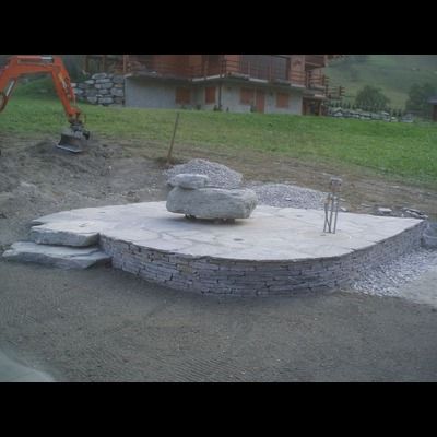 Un gros rocher est posé sur une plate-forme en béton.